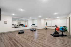 Fort Wayne apartment for rent - a gym with treadmills and weights in a room with white walls and floors at 41 North Apartments, Indiana, 46835