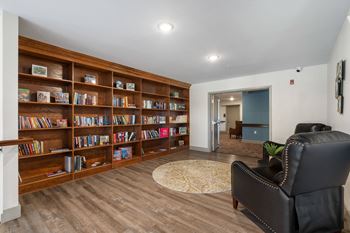 A library with a black leather chair and a book shelf