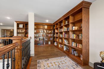 A library with wooden shelves and a staircase