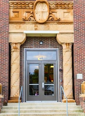 Shelbyville apartment for rent - the front door of a brick building with a glass door  at Hendricks Pointe Apts, Shelbyville, IN, 46176