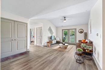 A living room with white walls and a ceiling fan