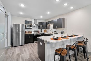 Redesigned kitchen with stainless steel appliances and a large island with stools