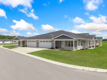 A house with a driveway and lawn in front of it