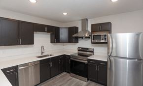 Fort Wayne apartment for rent - a kitchen with stainless steel appliances and black cabinets at Morada at Maysville, Fort Wayne, IN 46815