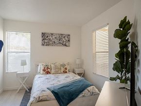 Phoenix apartment for rent - a white bedroom with a bed and a plant