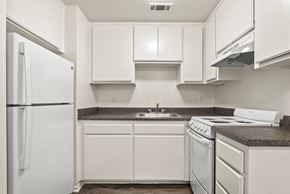Montclair apartment for rent - A white refrigerator is on the left in a kitchen with white cabinets and a white stove.