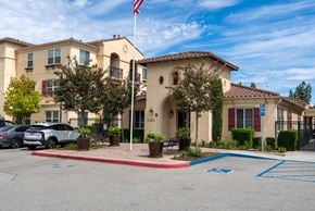 Chino apartment for rent - A building with a flag on top and a car parked in front.