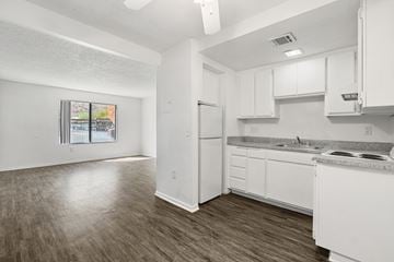 Palm Springs apartment for rent - A kitchen with white cabinets and a refrigerator.