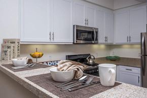Chino apartment for rent - a kitchen with white cabinets and a counter top