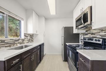 Mission Viejo apartment for rent - A kitchen with dark brown cabinets and stainless steel appliances.