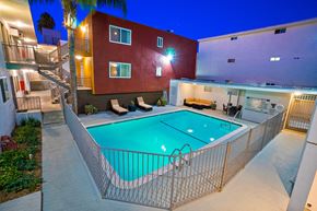Van Nuys apartment for rent - A red building with a pool in front.