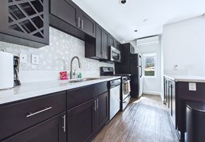 Los Angeles apartment for rent - A kitchen with black cabinets and a white counter.