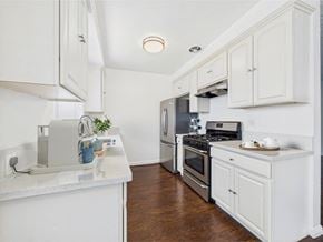 Santa Monica apartment for rent - A kitchen with white cabinets and a marble countertop.