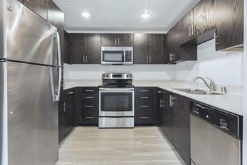 Ventura apartment for rent - A modern kitchen with black cabinets and stainless steel appliances.