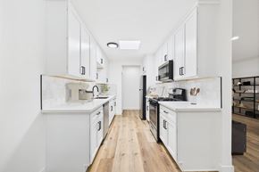 Los Angeles apartment for rent - A modern kitchen with white cabinets and black appliances.
