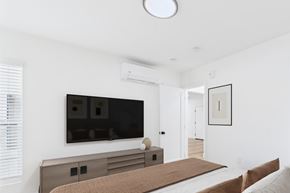 Los Angeles apartment for rent - A modern bedroom with a large bed and a flat screen TV mounted on the wall.