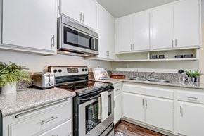 Los Angeles apartment for rent - A white kitchen with a black stove top oven and microwave.