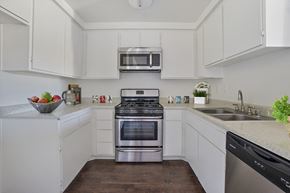 Northridge apartment for rent - A modern kitchen with white cabinets and stainless steel appliances.