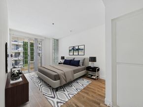 Los Angeles apartment for rent - A bedroom with a large bed and a balcony with a view of a building.