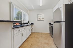 Sherman Oaks apartment for rent - A kitchen with white cabinets and a black countertop.