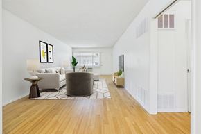 Sherman Oaks apartment for rent - A living room with a white couch and a grey ottoman.