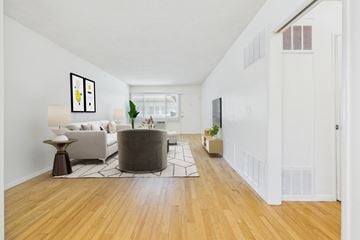 Sherman Oaks apartment for rent - A living room with a white couch and a grey ottoman.