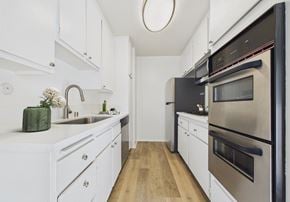 Sherman Oaks apartment for rent - A modern kitchen with white cabinets and stainless steel appliances.