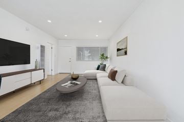 Van Nuys apartment for rent - A modern living room with a white sofa and a black rug.