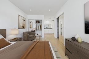 Van Nuys apartment for rent - A bedroom with a large bed and a brown rug.