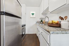 Van Nuys apartment for rent - A kitchen with a stainless steel refrigerator and white cabinets.