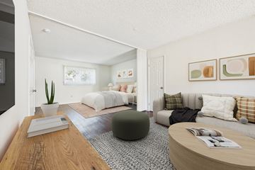 Van Nuys apartment for rent - A living room with a grey couch and a green ottoman.