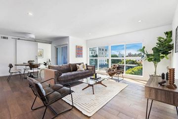 West Hollywood apartment for rent - A living room with a couch, chairs, and a table with a vase on it.