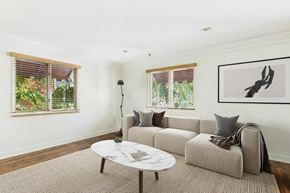 West Hollywood apartment for rent - A living room with a grey couch, a white coffee table, and a painting on the wall.