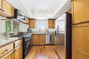 West Hollywood apartment for rent - A kitchen with wooden cabinets and a stainless steel refrigerator.