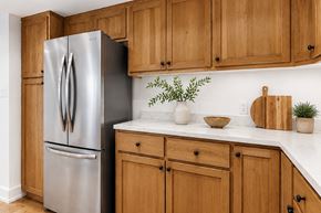 West Hollywood apartment for rent - A stainless steel refrigerator stands next to wooden cabinets in a kitchen.