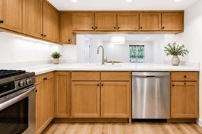West Hollywood apartment for rent - A kitchen with wooden cabinets and a stainless steel dishwasher.