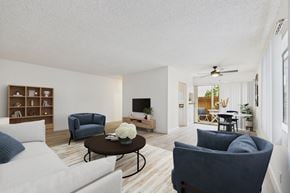Sherman Oaks apartment for rent - A living room with a white couch, a blue chair, and a coffee table with a flower on it.