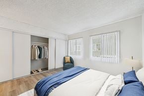 Sherman Oaks apartment for rent - A bedroom with a bed, pillows, a chair, and a wardrobe.