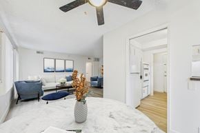Sherman Oaks apartment for rent - A living room with a white ceiling fan and a grey sofa.
