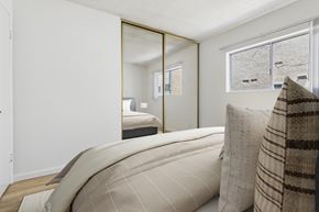 Sherman Oaks apartment for rent - A bedroom with a large bed and a mirror on the wall.