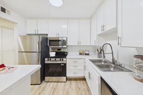 Sherman Oaks apartment for rent - A kitchen with white cabinets and a black stove.