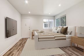 Van Nuys apartment for rent - A bedroom with a bed, a nightstand, and a mirror on the wall.