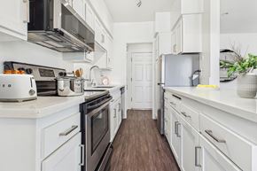 Van Nuys apartment for rent - A white kitchen with a stove top oven and a refrigerator.