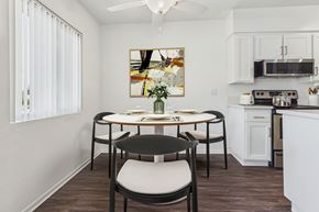 Van Nuys apartment for rent - A dining room with a table set for two and a painting on the wall.