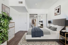 Van Nuys apartment for rent - A bedroom with a large bed and a plant.