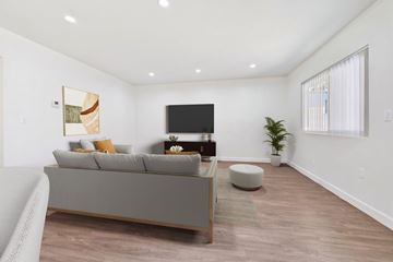 Van Nuys apartment for rent - A living room with a grey couch and a television.