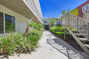 Van Nuys apartment for rent - A sunny day in a residential area with a pathway and plants.