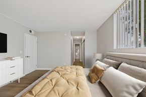 North Hills apartment for rent - A bedroom with a large bed and a television on the wall.