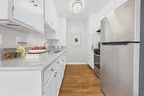 North Hills apartment for rent - A kitchen with white cabinets and a fridge.