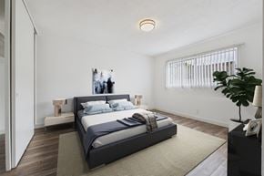 Los Angeles apartment for rent - A bedroom with a large bed and a plant on the side table.